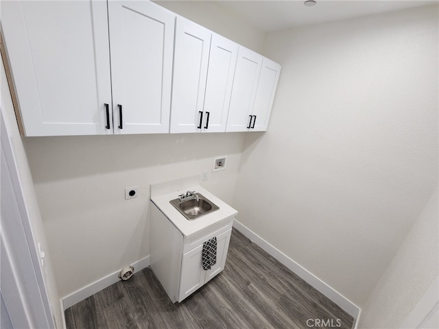 clothes washing area featuring cabinets, dark hardwood / wood-style flooring, sink, and electric dryer hookup