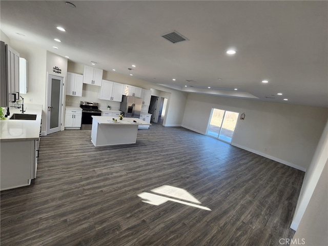 kitchen featuring white cabinets, a center island, stainless steel appliances, sink, and dark hardwood / wood-style floors