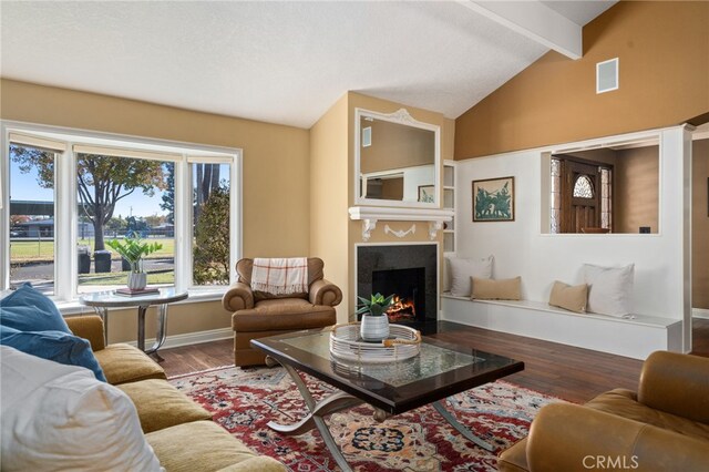 living room featuring vaulted ceiling with beams and wood-type flooring