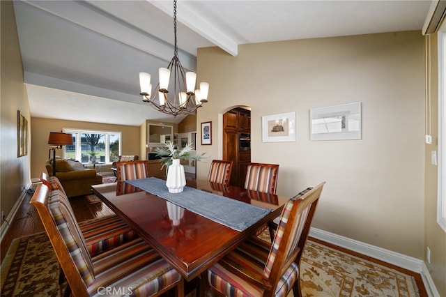 dining room with hardwood / wood-style flooring, vaulted ceiling with beams, and an inviting chandelier