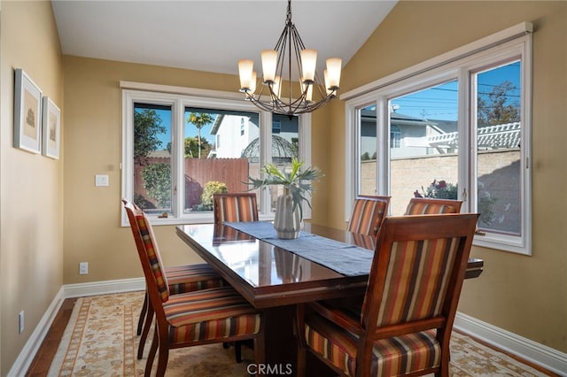 dining space featuring lofted ceiling and an inviting chandelier