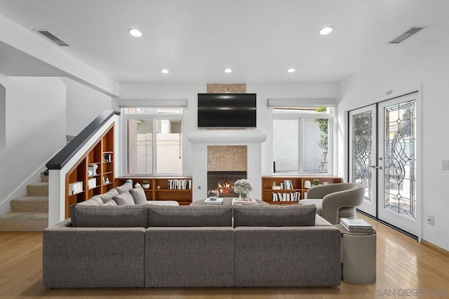 living room featuring light hardwood / wood-style flooring and a tiled fireplace