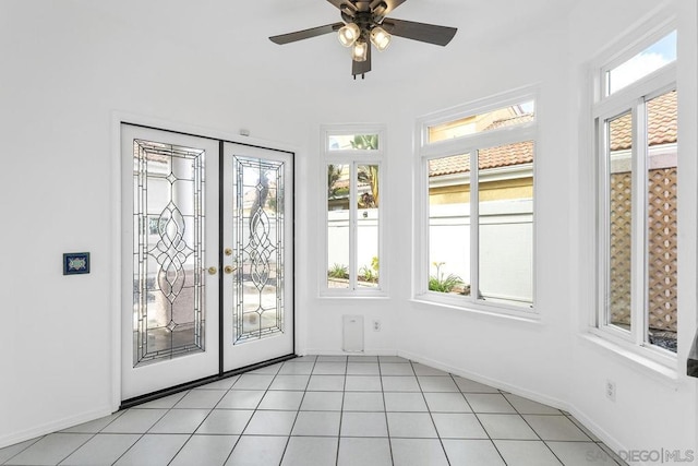 unfurnished sunroom with plenty of natural light, ceiling fan, and french doors