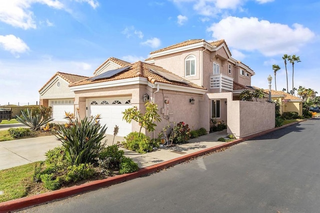 mediterranean / spanish house featuring solar panels and a garage