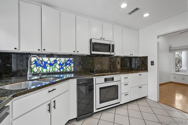 kitchen with tasteful backsplash, white cabinetry, sink, and stainless steel appliances