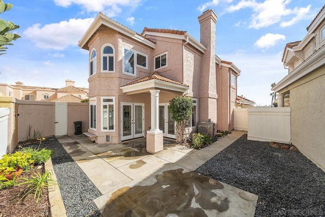 back of house featuring ac unit, french doors, and a patio area