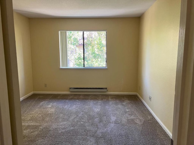 carpeted spare room featuring a baseboard heating unit