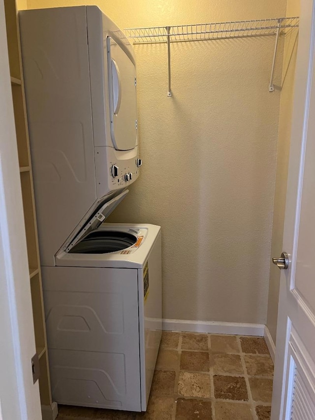 clothes washing area featuring stacked washer and dryer