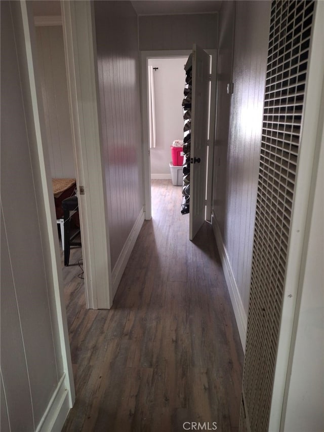 hallway featuring wood walls and dark wood-type flooring