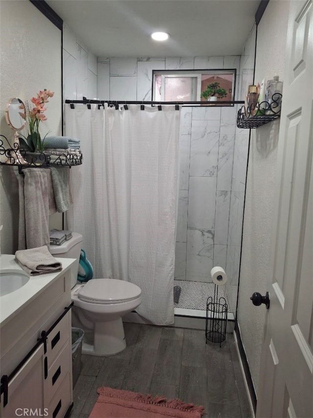 bathroom with hardwood / wood-style flooring, vanity, toilet, and a shower with shower curtain