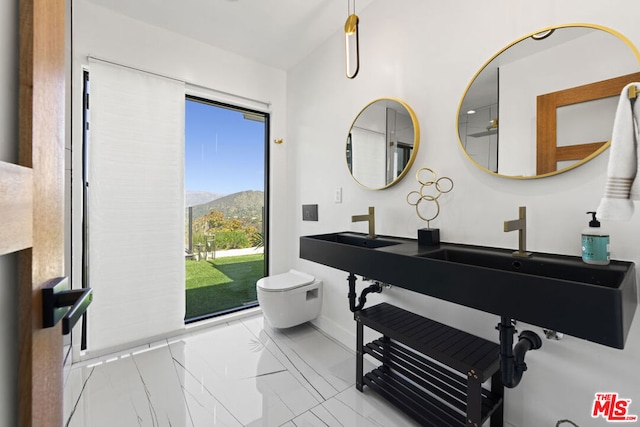 bathroom featuring double sink, toilet, and a mountain view