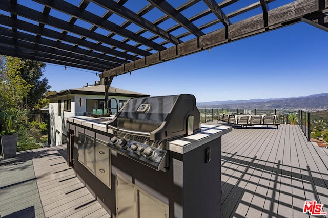 wooden deck featuring area for grilling, a mountain view, a pergola, and a grill