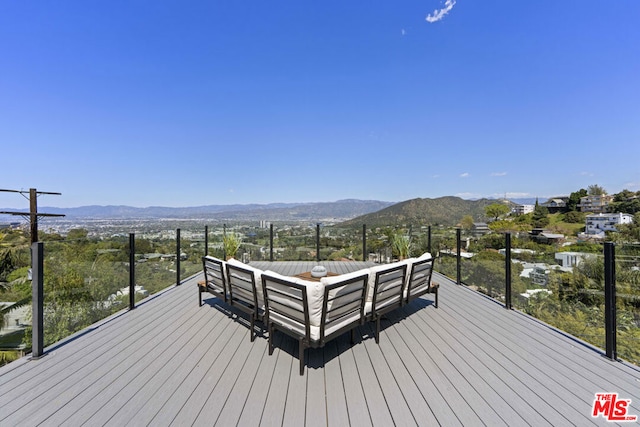 wooden terrace with a mountain view and outdoor lounge area