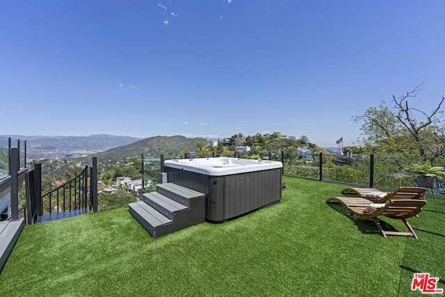 view of yard with a hot tub and a mountain view