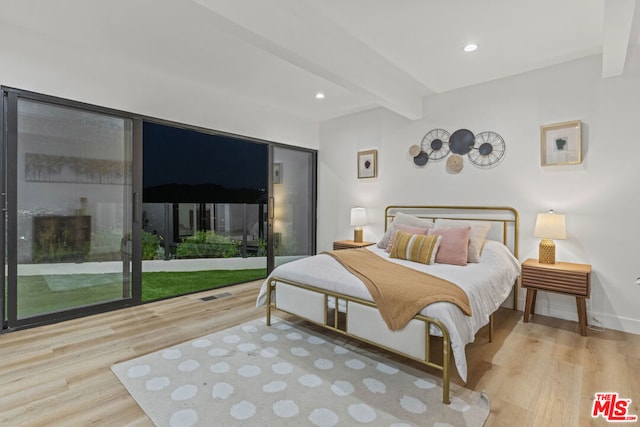 bedroom with hardwood / wood-style flooring and beam ceiling