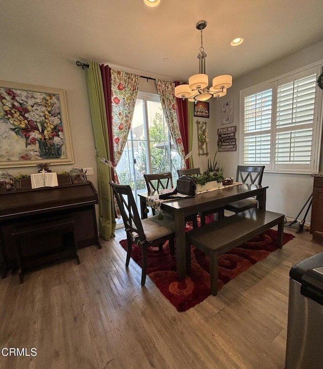 dining room with wood-type flooring and an inviting chandelier