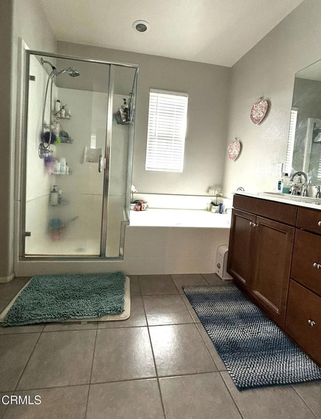 bathroom with tile patterned floors, vanity, and plus walk in shower