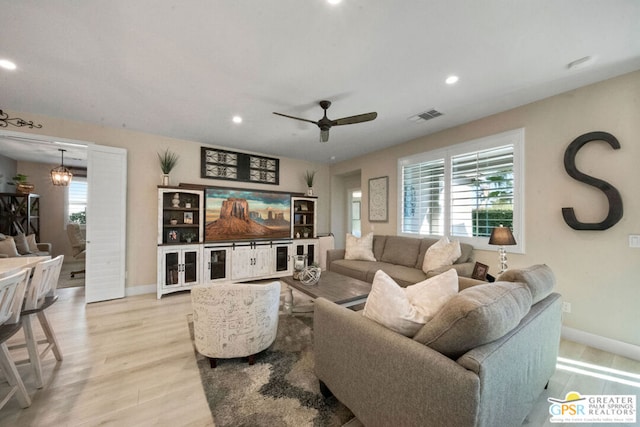 living room with ceiling fan and light hardwood / wood-style flooring