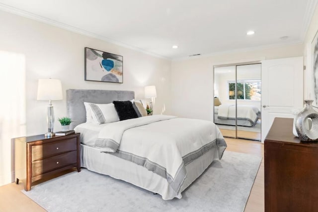 bedroom featuring a closet, ornamental molding, and light hardwood / wood-style floors