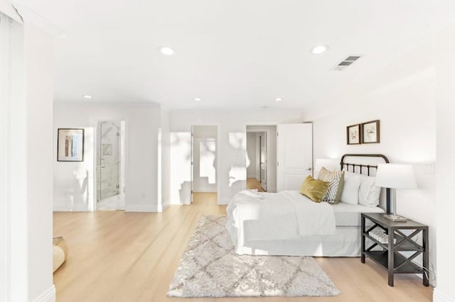 bedroom with ensuite bathroom, light hardwood / wood-style flooring, and crown molding