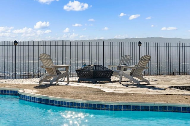 view of swimming pool featuring an outdoor fire pit