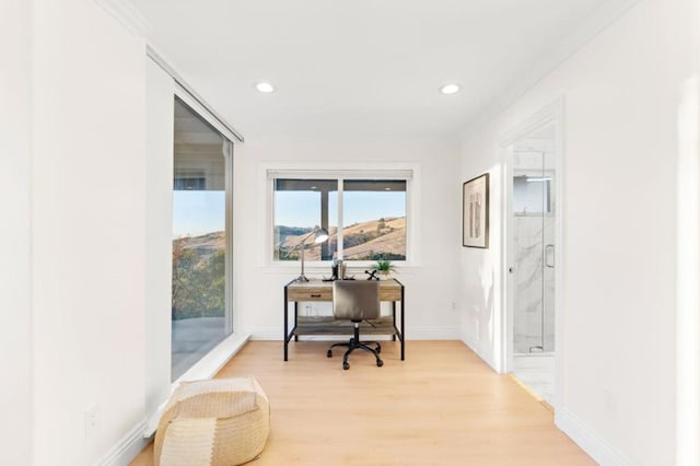 office space with light wood-type flooring and crown molding