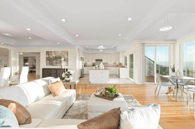 living room featuring light wood-type flooring, beamed ceiling, and crown molding