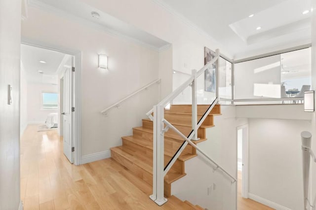 staircase featuring ornamental molding and hardwood / wood-style floors