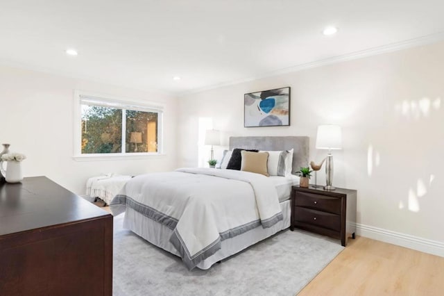 bedroom featuring ornamental molding and light wood-type flooring