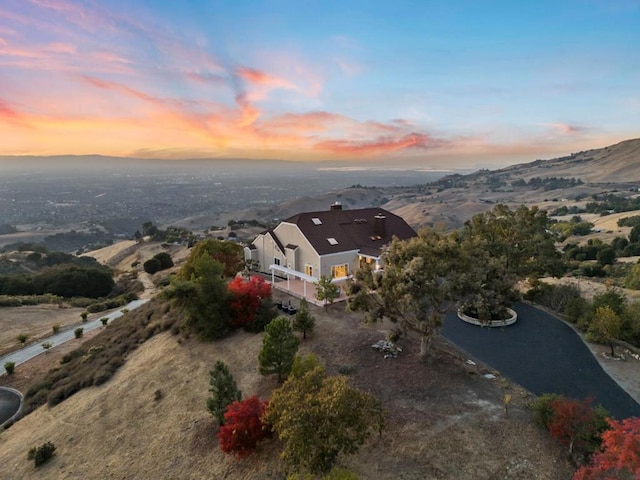 aerial view at dusk featuring a mountain view