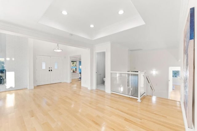 interior space with light hardwood / wood-style flooring and a raised ceiling