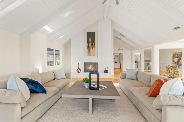 living room with lofted ceiling with beams and a fireplace