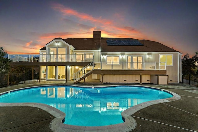 pool at dusk featuring a patio