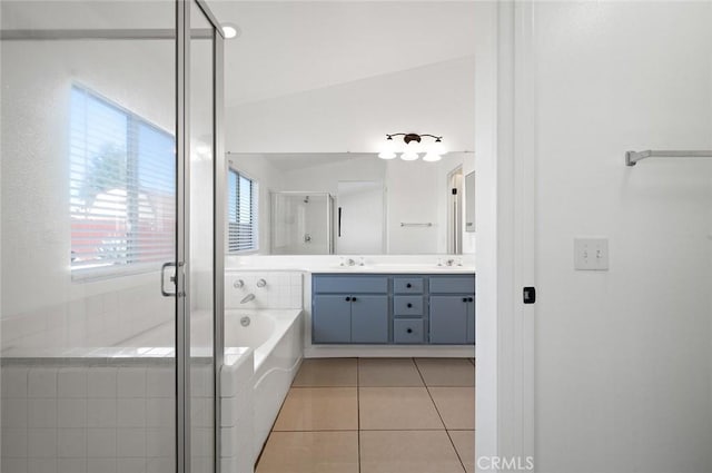 bathroom with tile patterned floors, vanity, separate shower and tub, and vaulted ceiling