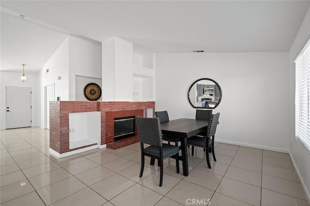 tiled dining area featuring vaulted ceiling