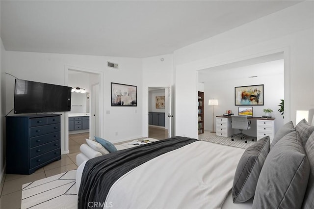 bedroom featuring light tile patterned floors, connected bathroom, and vaulted ceiling