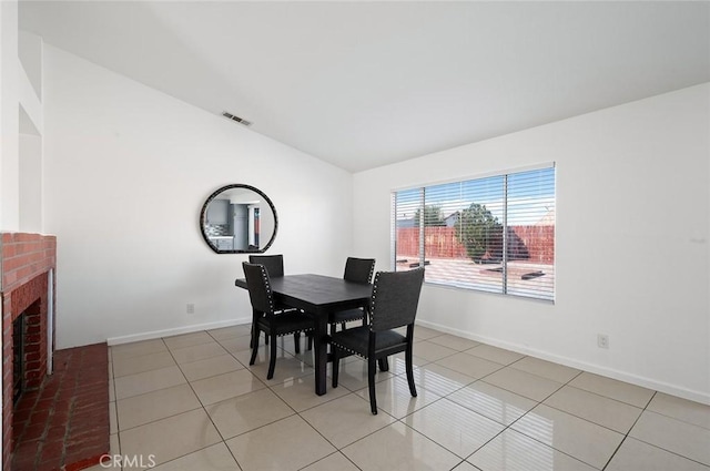 dining space with a fireplace and light tile patterned floors