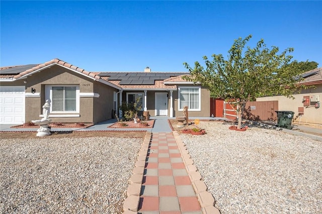 ranch-style house featuring solar panels and a garage