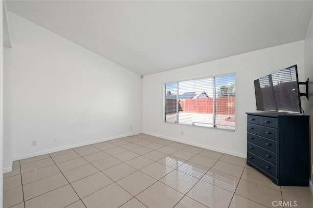 tiled empty room with vaulted ceiling