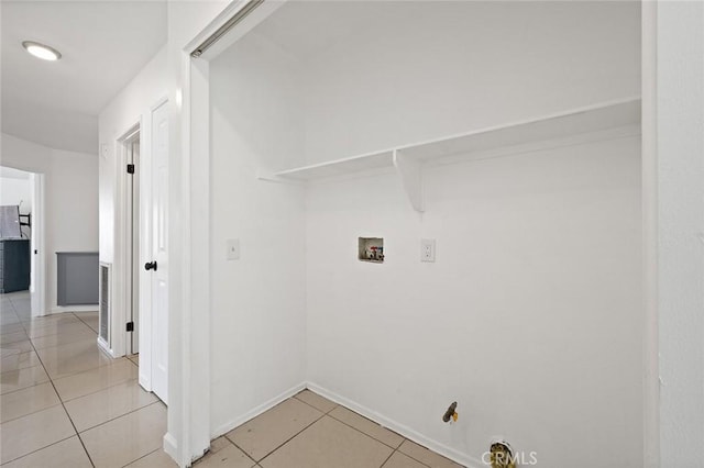 clothes washing area with hookup for a washing machine, hookup for a gas dryer, and light tile patterned floors