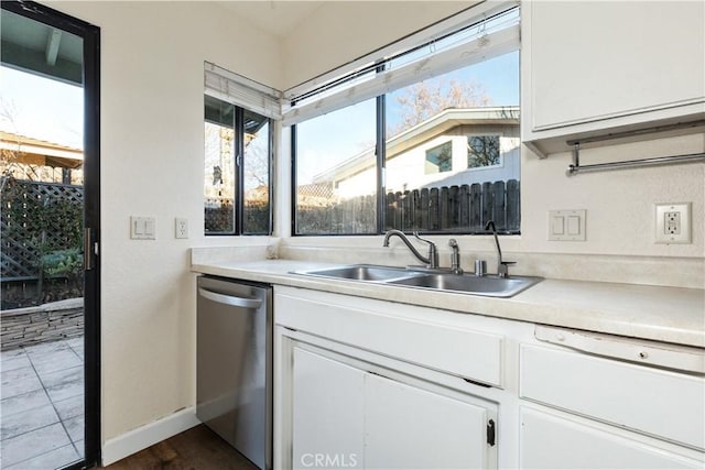 kitchen with a wealth of natural light, dishwasher, white cabinets, and sink