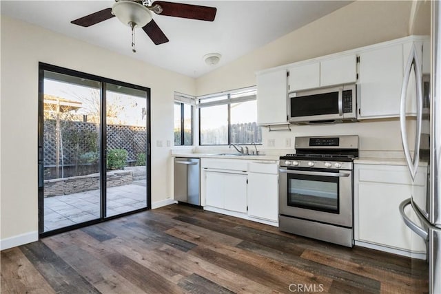 kitchen with white cabinets, dark wood-type flooring, stainless steel appliances, vaulted ceiling, and ceiling fan