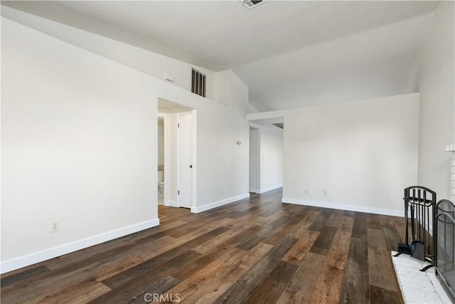 spare room featuring vaulted ceiling and dark hardwood / wood-style flooring