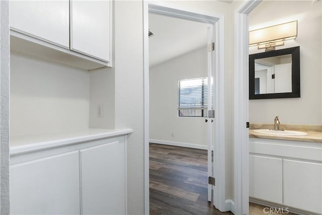 interior space featuring dark hardwood / wood-style flooring, lofted ceiling, and sink