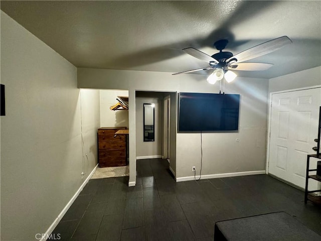 unfurnished room with a textured ceiling, ceiling fan, and dark hardwood / wood-style flooring