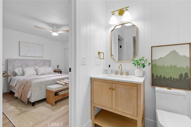 bedroom with ceiling fan, light wood-type flooring, and sink