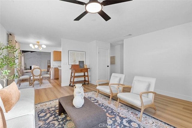 living room featuring ceiling fan and light hardwood / wood-style flooring