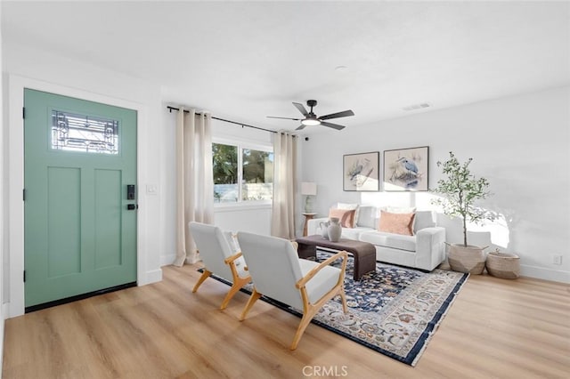 living room featuring light hardwood / wood-style flooring and ceiling fan