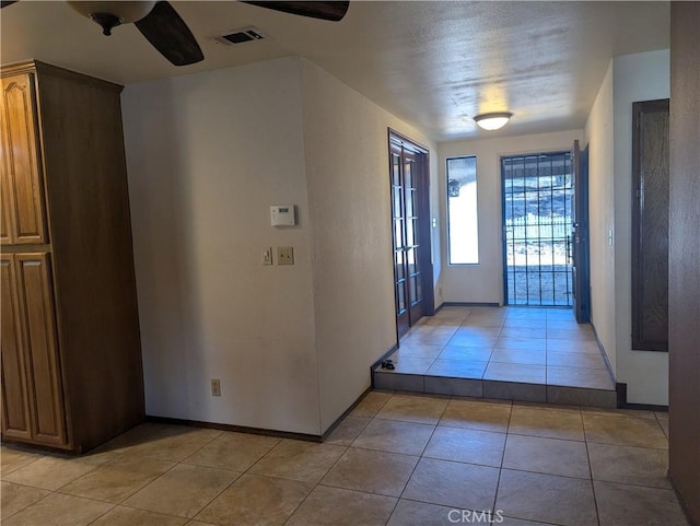 entrance foyer featuring ceiling fan and light tile patterned floors