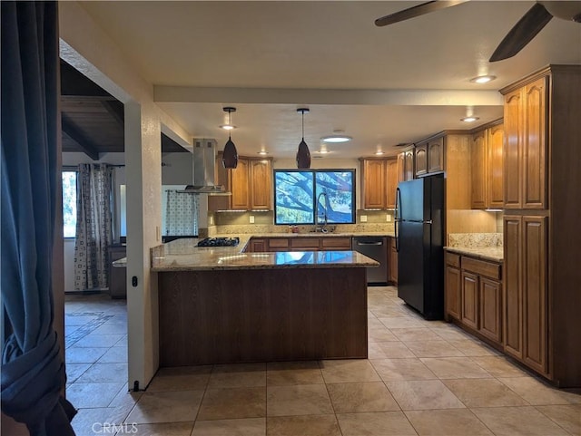 kitchen featuring kitchen peninsula, decorative light fixtures, range hood, black appliances, and sink